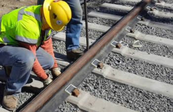 Construction workers installing rail boots